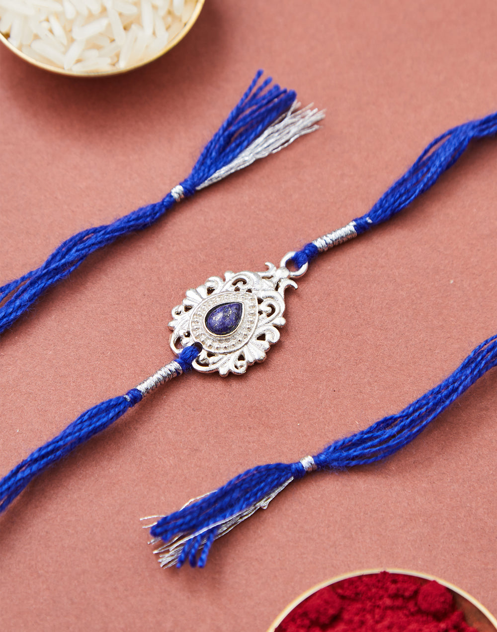 Blue Metal Tear Drop Motif Rakhi With Blue Stone